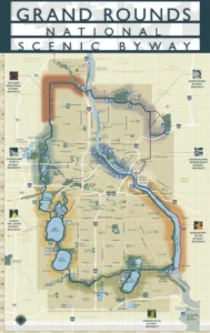 A map titled 'Grand Rounds National Scenic Byway,' showing various routes, lakes, and parks, with markers indicating notable locations in the Minneapolis and Saint Paul area, displayed on a light background.