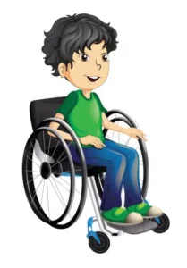 A young boy with curly dark hair sitting in a wheelchair, wearing a green shirt and blue jeans, with a cheerful expression and green shoes.