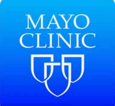 The Mayo Clinic logo features the text 'Mayo Clinic' in white, above a stylized blue shield design, all set against a gradient blue background. Relevant for Spinal cord injury Mayo Clinic Clinical Trials.