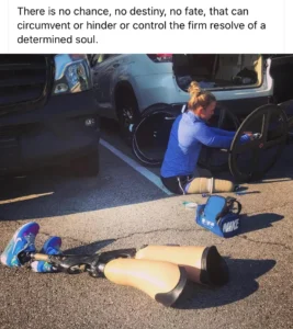 A woman in athletic gear is adjusting a wheelchair wheel in a parking lot. Two prosthetic legs are lying beside her. A quote about determination is displayed above the image. This Facebook blog about wheelchair life is complicated. Let’s help each other out with advice.