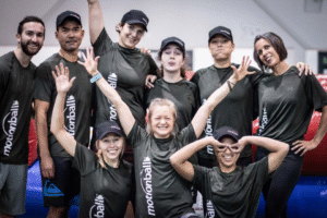 A team of motion ball players pose for a picture after winning the championship wearing your black jerseys