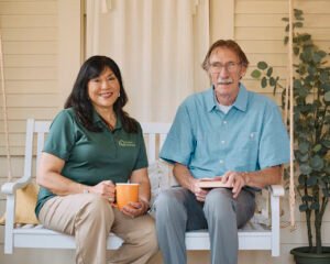 Healthcare assistant, Sean seated with an elderly client in their home