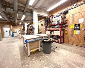 Indoor shop scene with work tables and woodworking tools on the side Wild that clean north Forge fabrication lab