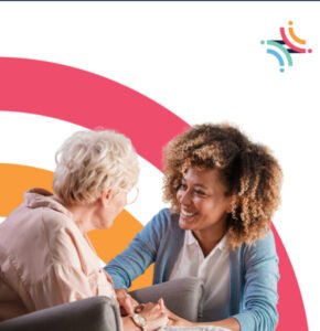 A young woman engaging in conversation with an older woman while holding her hands, both appearing attentive and warm. The background features colorful circular shapes. Manitoba Possible accessibility is highlighted in the image's context.