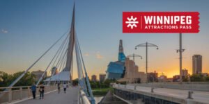 A pedestrian bridge in Winnipeg with modern architecture, featuring people walking. The skyline includes a notable building with a blue exterior. In the corner, a promotional graphic displays 'WINNIPEG ATTRACTIONS PASS'.