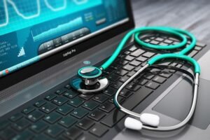 A black laptop with a stethoscope placed on the keyboard, illustrating the concept of superior health care and medical technology. The screen displays health data graphs.