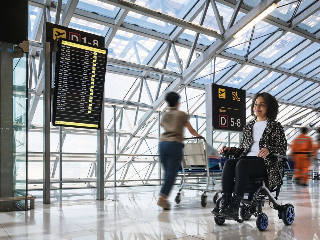 A woman sitting in a wheelchair while smiling.