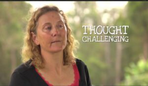 A woman with honey colored hair wearing black and red clothes.