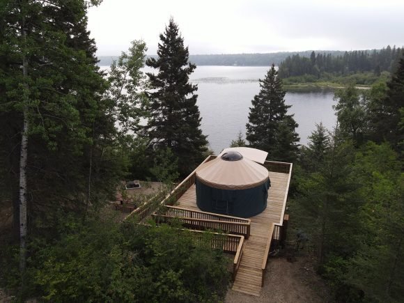 A scenic spot at the shore of the lake with a pavilion surrounded by lush trees.