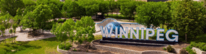 An overhead view of the large Winnipeg sign at the Forks with some nice trails and bushes in the background