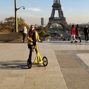 Alinker walking bike being used by woman in front of the Eiffel Tower in Paris
