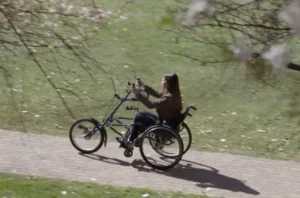 A girl sitting in a wheelchair navigating a path way