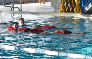 A spacious indoor swimming pool filled with water while a family enjoying swimming