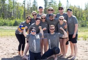 A team of motion ball players, Justin Gray, huddled together in the outdoors with trees and blue sky in the background