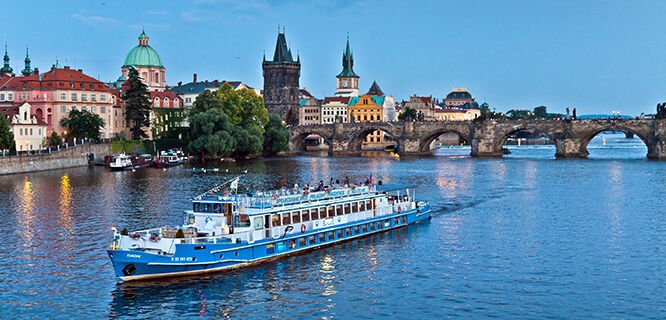 Extravagant looking river boat, cruising down the river with the beautiful sites of the city in the background against the blue sky