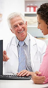 Female patient dressed in pink is speaking with her doctor male with a white lab coat quote and a stethoscope