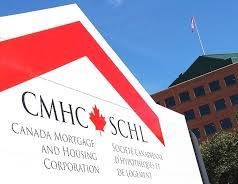 Oh white sign said against a blue sky outdoors with the initials CMHC with a Canadian flag and the red peak roof symbol