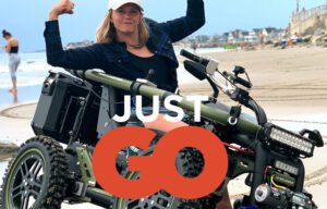 Picture shows young lady on a four-wheel drive terrain hopper on the beach sand on a bit of a hill on a tilt
