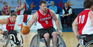 Canada's men's wheelchair basketball team poses together in their uniforms, showcasing teamwork and athleticism.