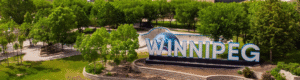 An overhead view of the large Winnipeg sign at the Forks with some nice trails and bushes in the background