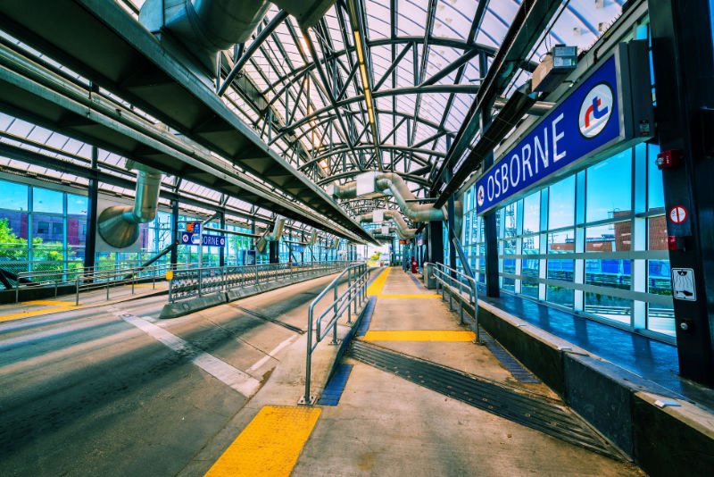 Picture shows a transit bus connection, shelter with a lot of glass and steel and blue, glowing side windows, but both lanes are empty of buses