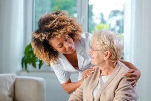 Elderly female client is tended to by female healthcare aide in a home