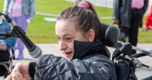 A girl in a wheelchair talking in a microphone