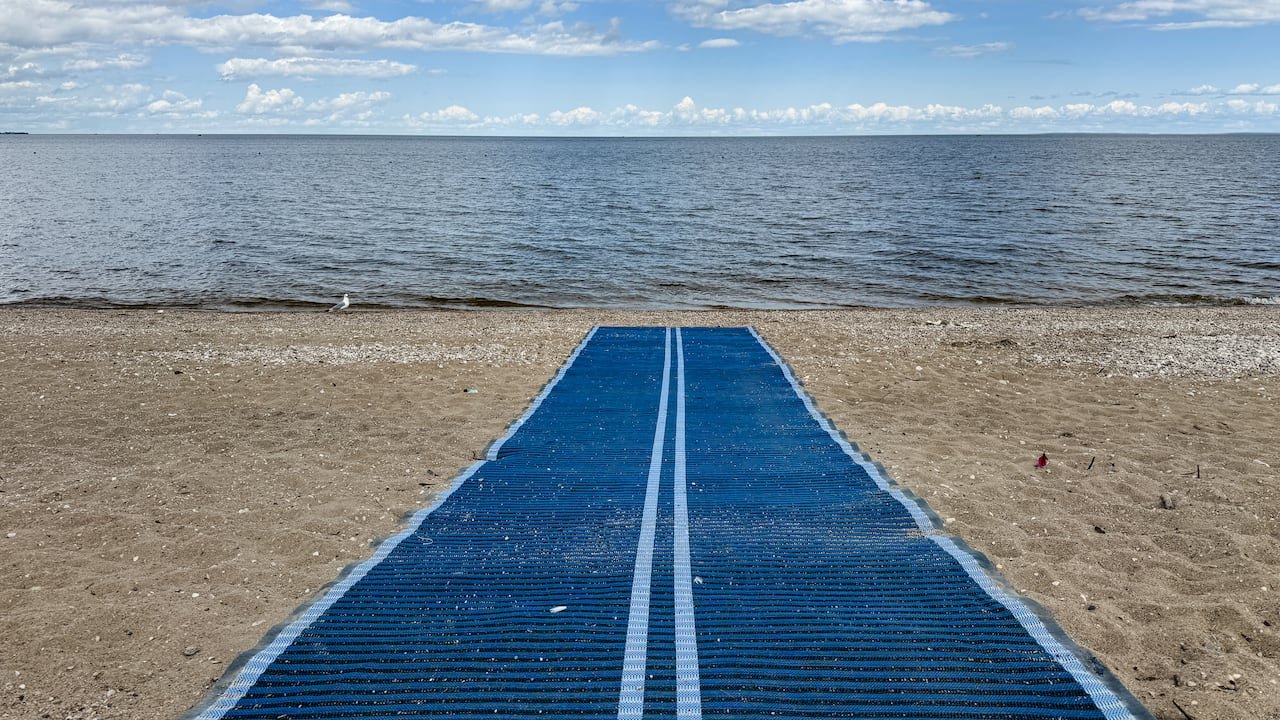Picture of Lake Beach shows accessibility mat, allowing persons in a wheelchair to go down to the beach